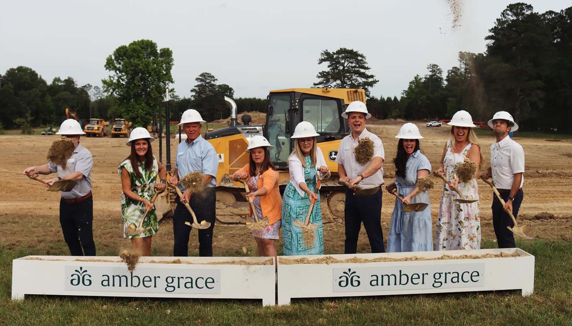 group of people shovel dirt for groundbreaking